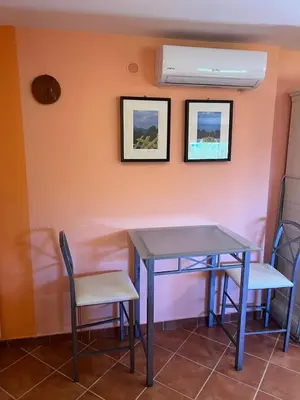 a table and chairs in a room with a wall at Suite Panoramic in Porticello