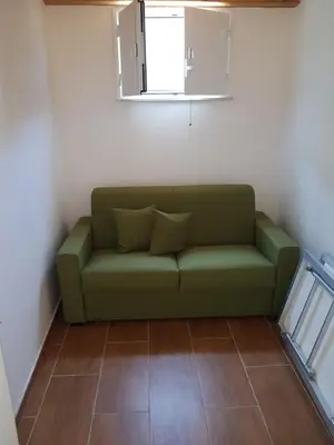 a green couch in a room with a window at Suite Panoramic in Porticello