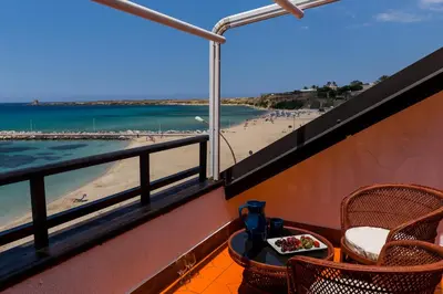 a balcony with a table and chairs and a beach at Vero Sicily - Villa San Giorgio in Cinisi
