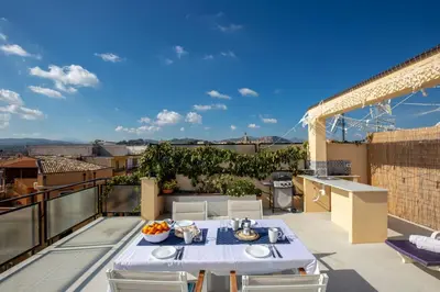 a patio with a table and chairs on a balcony at Maison Brigitte - Solemar Sicilia in Santa Flavia