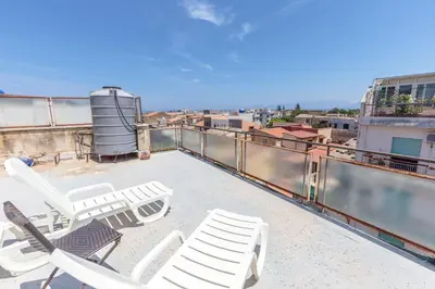 a group of chairs on the roof of a building at Maison Brigitte - Solemar Sicilia in Santa Flavia