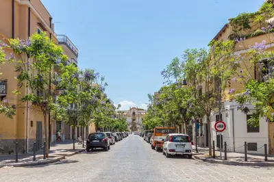 a street with cars parked on the side of the road at Maison Brigitte - Solemar Sicilia in Santa Flavia