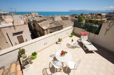 a patio with a table and chairs on a balcony at 4Canti Case Vacanze in Castellammare del Golfo