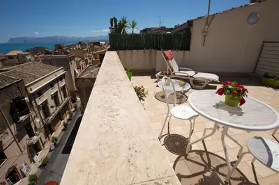 a patio with a table and chairs on a balcony at 4Canti Case Vacanze in Castellammare del Golfo