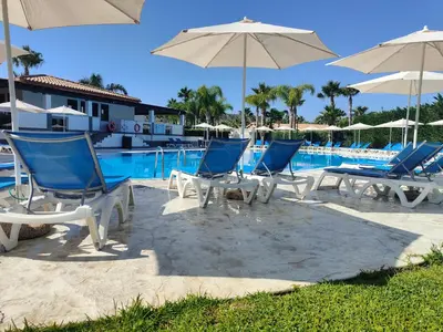 a group of chairs and umbrellas next to a pool at Residence Hydria in Campofelice di Roccella