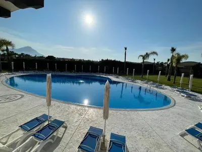 a large swimming pool with chairs and umbrellas at Residence Hydria in Campofelice di Roccella