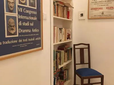 a book shelf with books and a chair in a room at villa Anna Silvia Makari fiction rai 1 Casa Saverio La Manna in San Vito lo Capo
