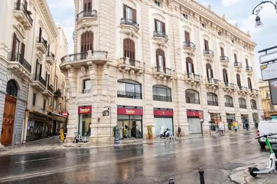 a large building on a city street in the rain at Palazzo Moncada Apartment in Palermo