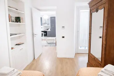 a white room with a bed and a mirror at Palazzo Moncada Apartment in Palermo