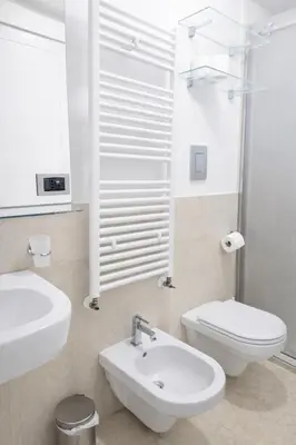 a white bathroom with a sink and a toilet at Palazzo Moncada Apartment in Palermo