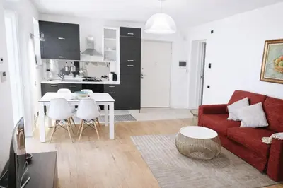 a living room with a red couch and a kitchen at Palazzo Moncada Apartment in Palermo