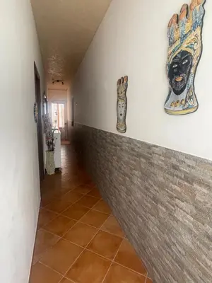 a hallway with two masks on the wall at Il Cortile in San Vito lo Capo