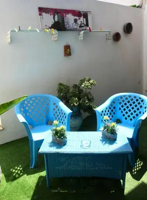 two blue chairs and a table with plants on it at Il Cortile in San Vito lo Capo