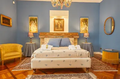 a bedroom with a bed and two lamps and a chair at Dimora dei Leoni in Palermo