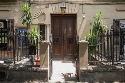 a wooden door on a building with a gate at Dimora dei Leoni in Palermo