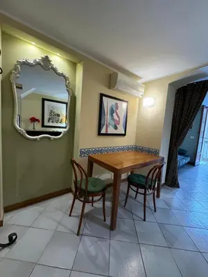 a dining room with a table and chairs and a mirror at Voile Rouge in Palermo