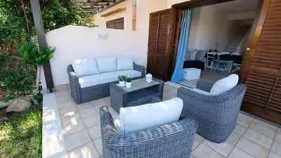 a patio with wicker chairs and a couch and a table at Blu Marea in Macari