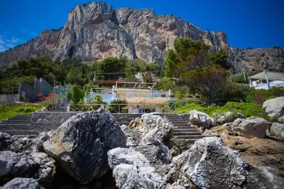 a mountain in the background with some rocks at Villa sul mare in Palermo