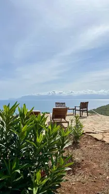 two benches sitting on a deck overlooking the ocean at Casa di Cri in San Vito lo Capo