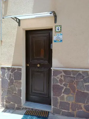 a brown door on the side of a building at casa Barone in Balestrate