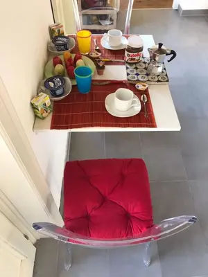 a table with a red chair in a kitchen at Casa del Contrabbasso in Palermo