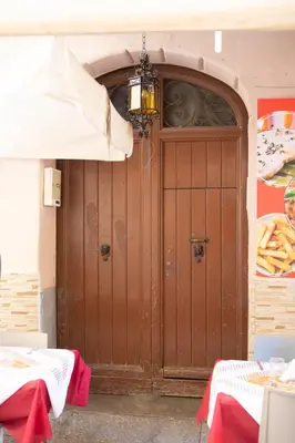 a large wooden door in a building with an umbrella at Casa del Contrabbasso in Palermo