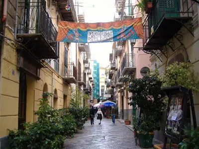a narrow alley with people walking down the street at Casa del Contrabbasso in Palermo