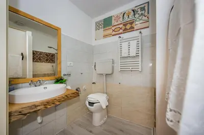 a bathroom with a sink and a toilet at Le Maioliche in Castellammare del Golfo