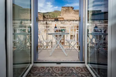 a view from the window of a table with a bottle of wine at Le Maioliche in Castellammare del Golfo
