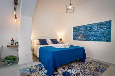 a bedroom with a bed with a blue table at Le Maioliche in Castellammare del Golfo