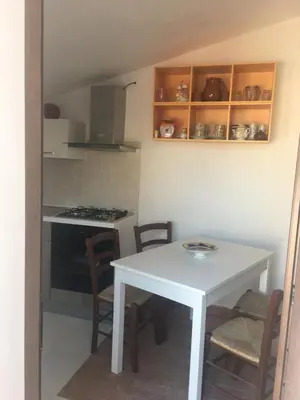 a small kitchen with a white table and chairs at Villino Fraginesi in Castellammare del Golfo
