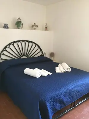 a blue bed with white towels on top of it at Villino Fraginesi in Castellammare del Golfo
