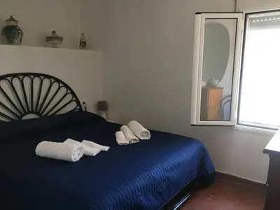 a bedroom with a blue bed with towels on it at Villino Fraginesi in Castellammare del Golfo