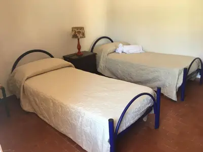 a room with two beds and a lamp on a table at Villino Fraginesi in Castellammare del Golfo