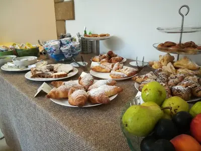 a table topped with plates of pastries and other foods at Hotel Concordia in Palermo