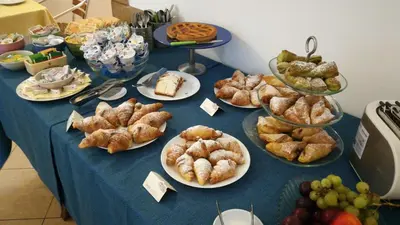 a blue table topped with plates of pastries and fruit at Hotel Concordia in Palermo