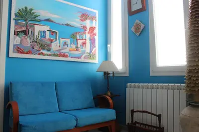a blue living room with a couch and a picture on the wall at La Maison del Sole in Palermo