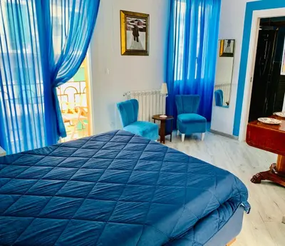 a bedroom with a blue bed and blue chairs at La Maison del Sole in Palermo