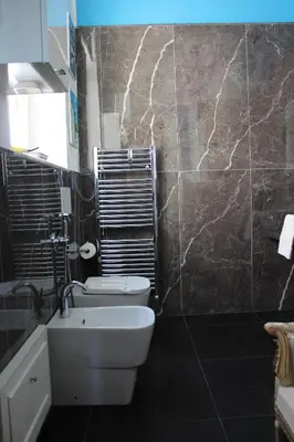 a bathroom with a white toilet and a sink at La Maison del Sole in Palermo
