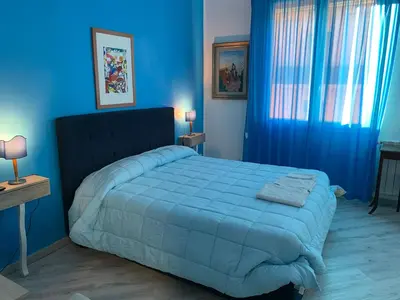 a blue bedroom with a large bed with blue sheets at La Maison del Sole in Palermo