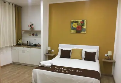 a bedroom with a large bed and a yellow wall at La Terrazza Palace B&B in Palermo