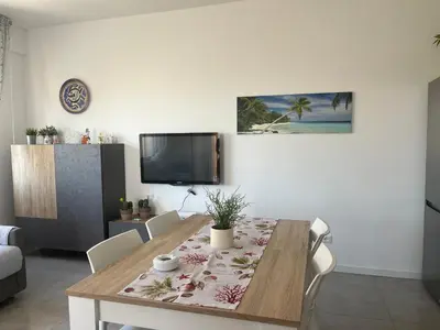 a living room with a table and a tv at Profumo di Mare 1 in Alcamo Marina