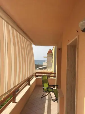 a balcony with a chair and a view of the beach at Profumo di Mare 1 in Alcamo Marina