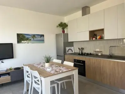 a kitchen with a table and some chairs and a counter at Profumo di Mare 1 in Alcamo Marina