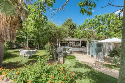 a garden with a table and a gazebo at Acacia Resort in Campofelice di Roccella