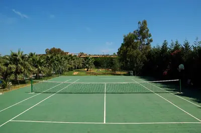a tennis court with a net on it at Acacia Resort in Campofelice di Roccella