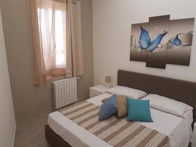 a bedroom with two beds and a butterfly painting on the wall at Vittorio Emanuele Appartamenti in Palermo
