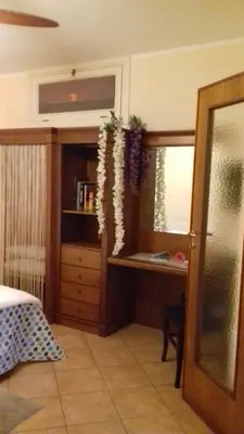 a bedroom with a bed and a dresser and a window at Appartamentino Cinisi in Cinisi