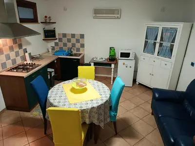 a kitchen with a table and chairs in a kitchen at Appartamentino Cinisi in Cinisi