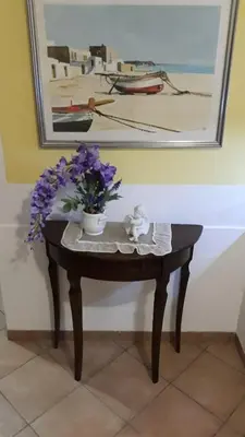 a table with a vase of purple flowers on it at Appartamentino Cinisi in Cinisi